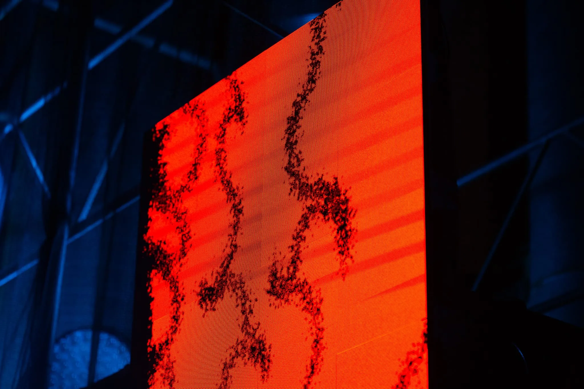 Close up of LED panel attached to scaffolding. Panel showing red distrorted graffiti