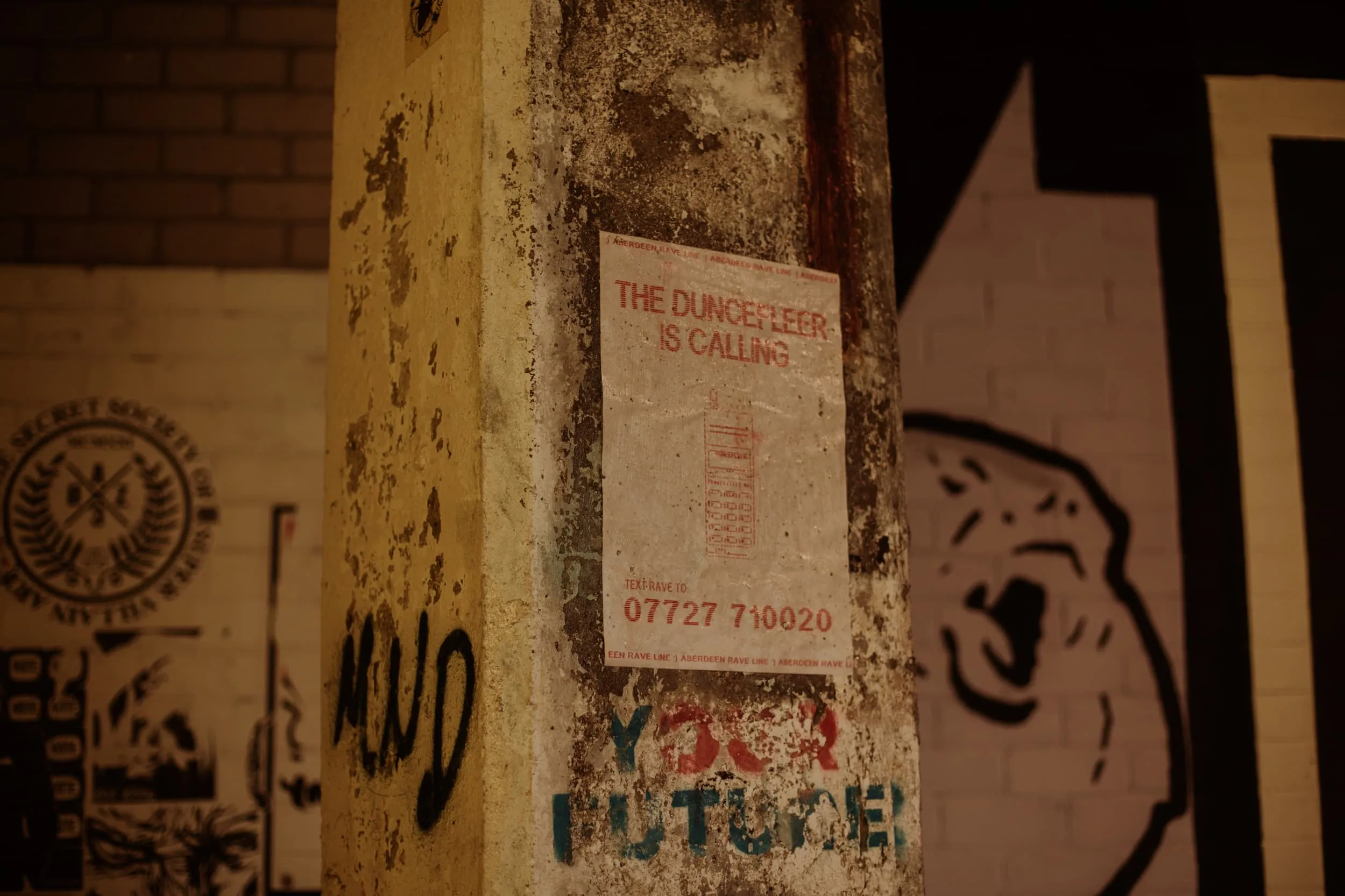 Paste-up poster on pillar reads the duncefleer is calling